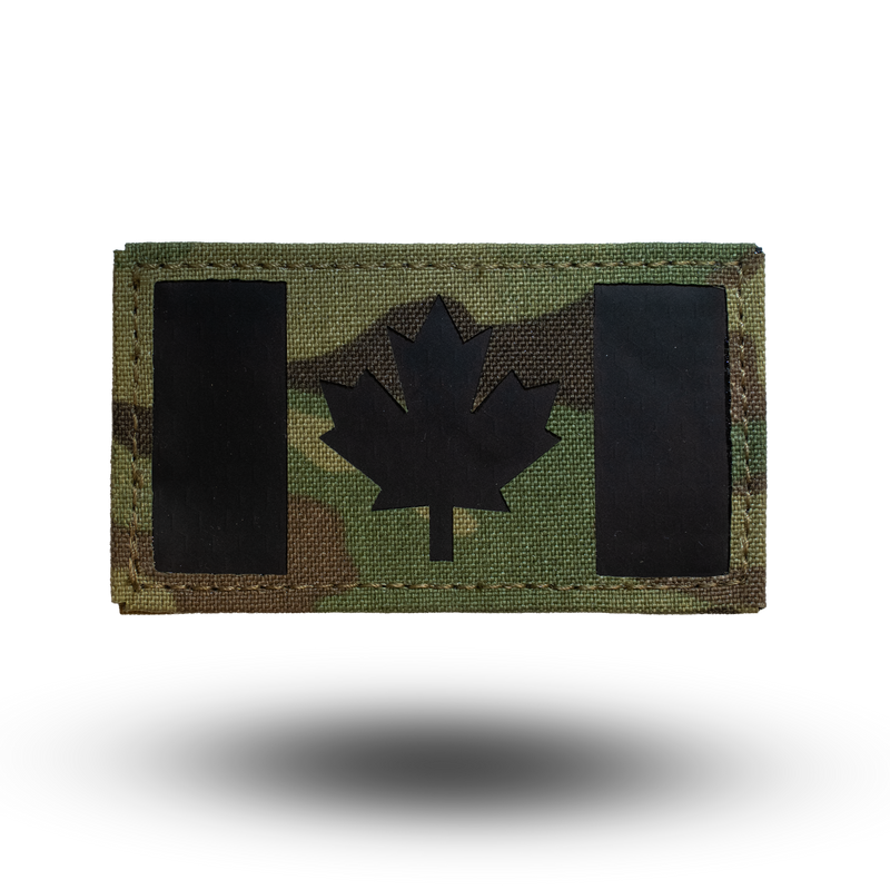 Multicam patterned patch with black maple leaf design on a white background