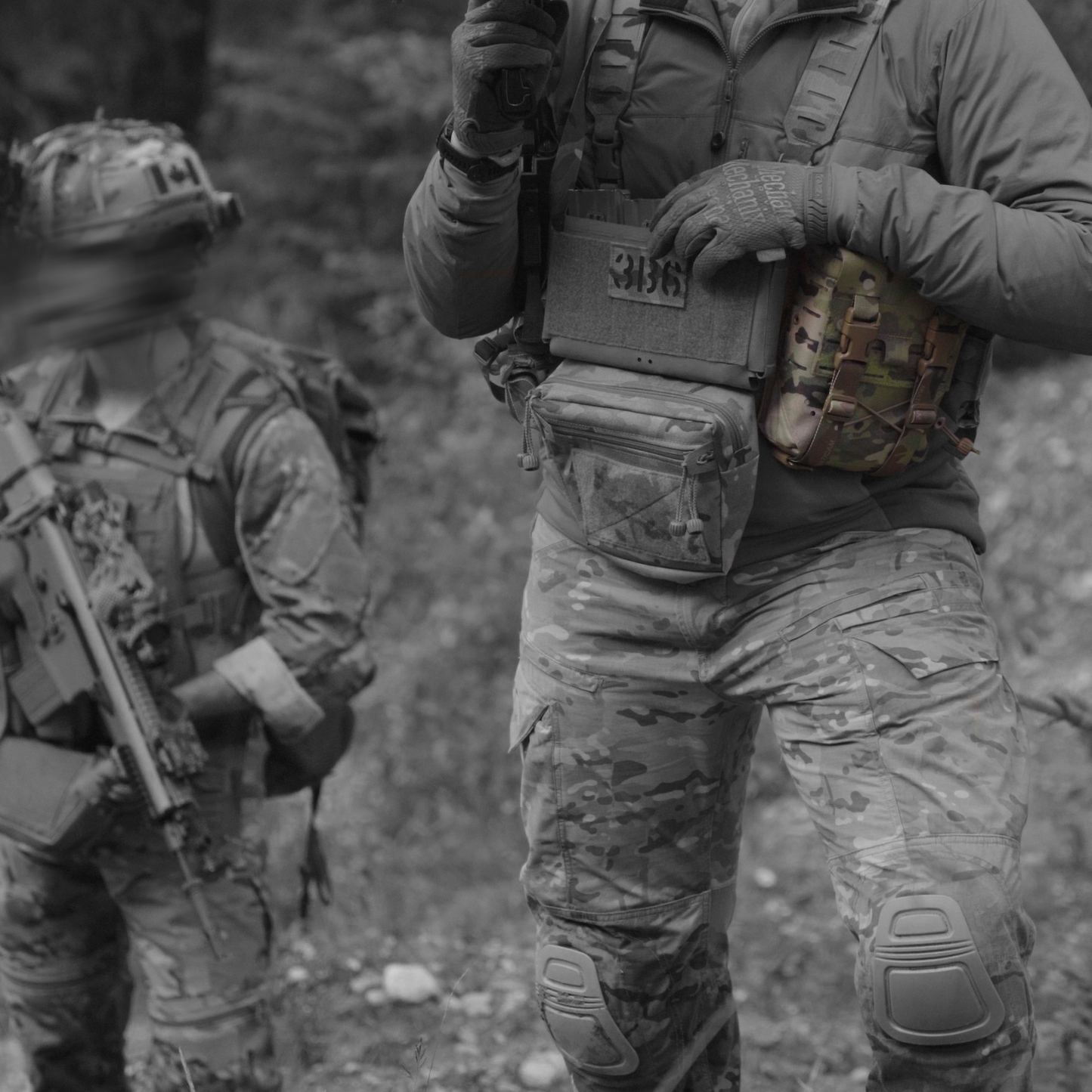 Two soldiers in camouflage gear in a forest setting